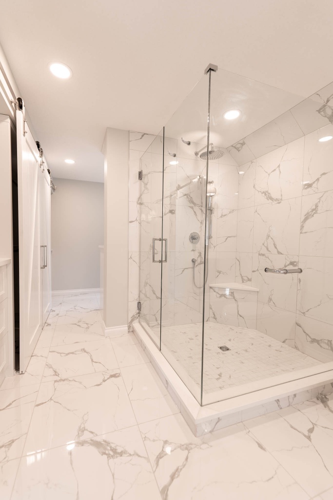 Luxurious walk-in shower. Glass doors, tile walls, rain fall shower head.