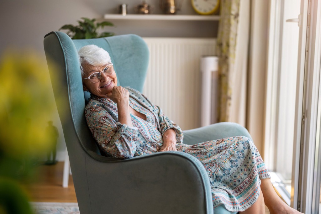 Elderly woman seating at home, aging in place